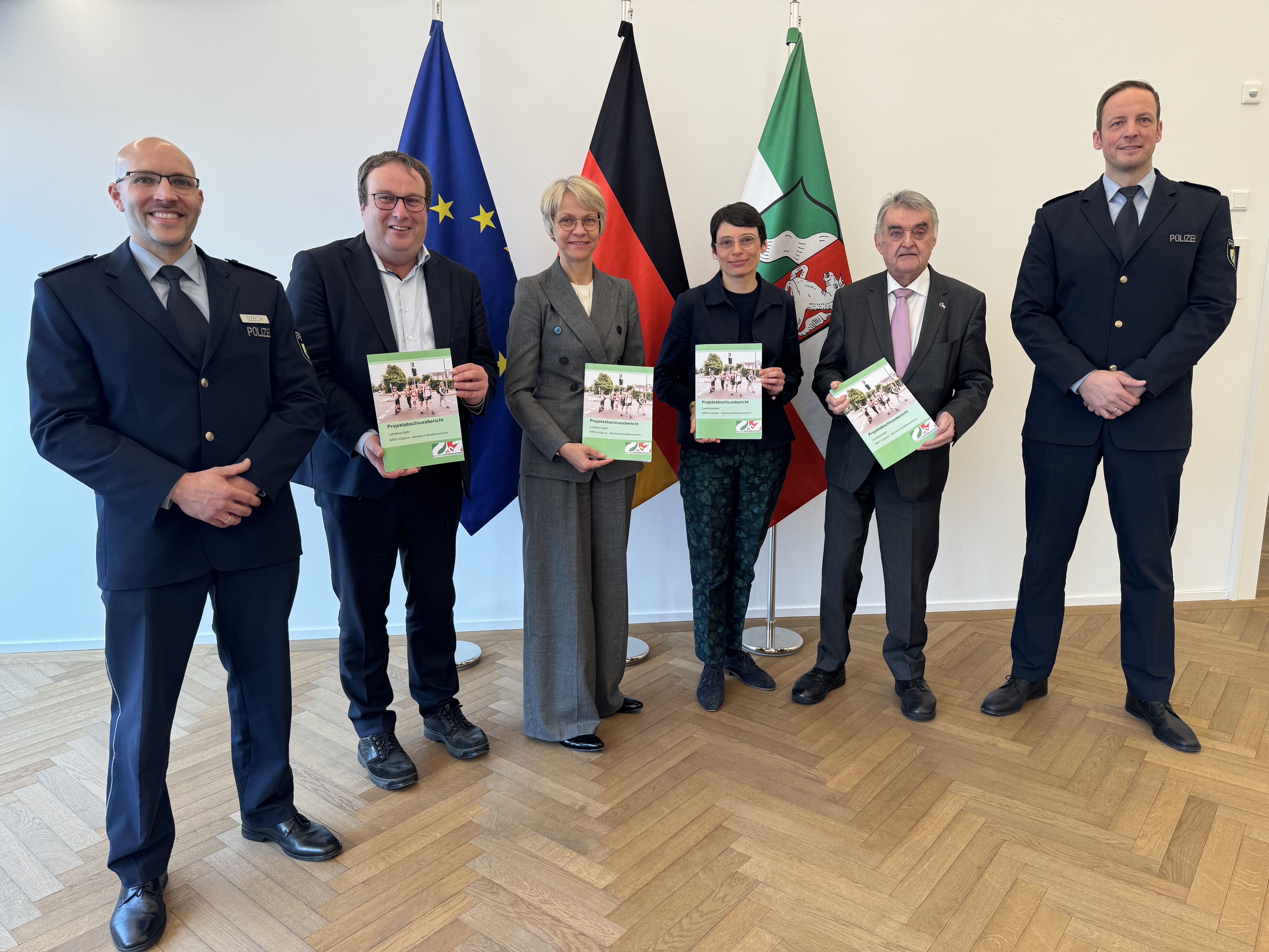 Projektleiter Markus Szech, Minister Krischer, Ministerin Feller, Ministerin Paul, Minister Reul, Polizeioberrat Seemann bei der Übergabe des Abschlussberichtes