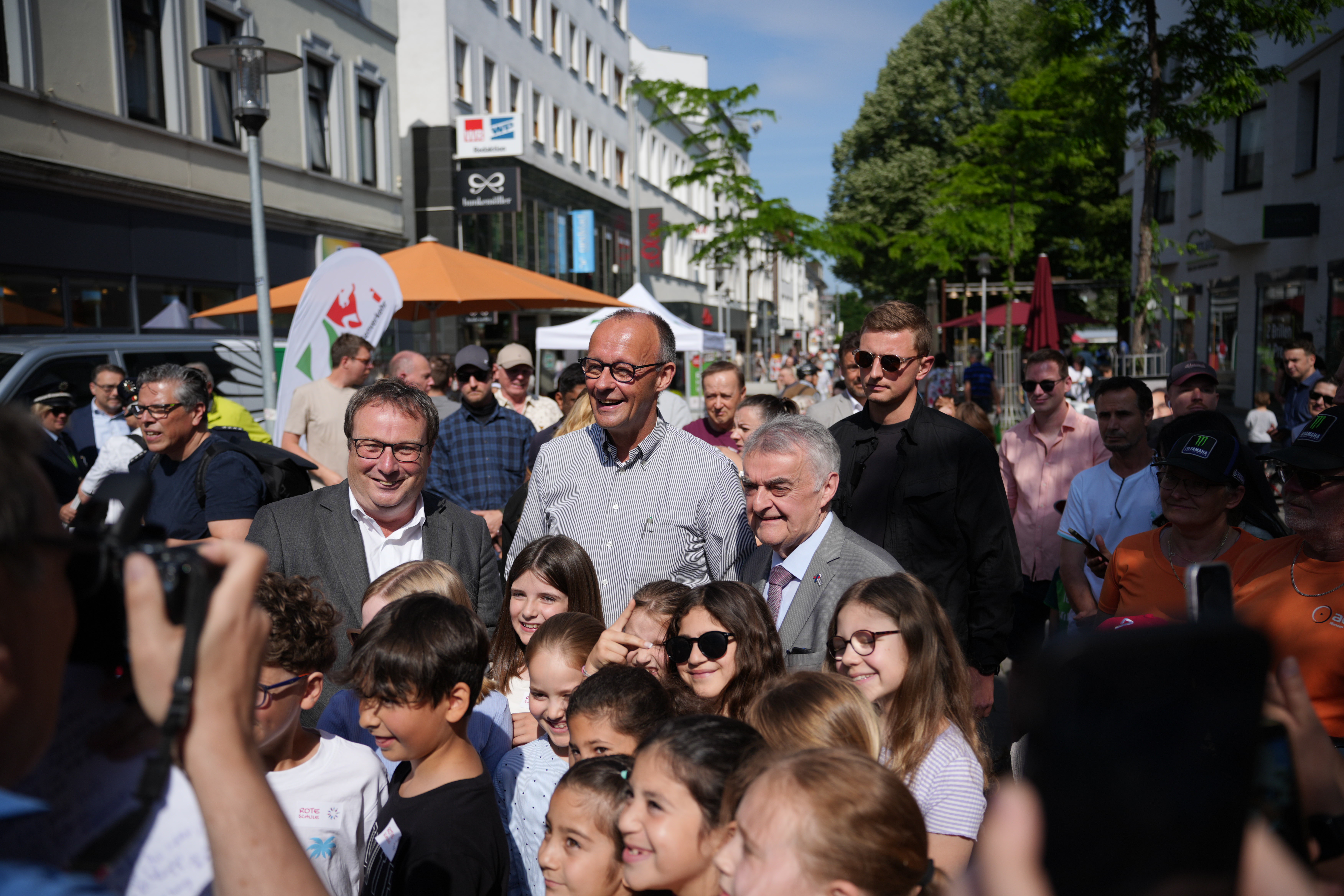 Bundeskanzler Merz mit den Ministern Krischer und Reul in einer Kindergruppe