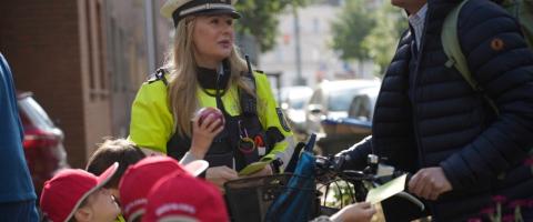 Kinder verteilen Dank- und Denkzettel an Verkehrsteilnehmende zusammen mit der Polizei