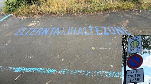 Auf einer Straße ist in blauer Farbe der Schriftzug "Elterntaxihaltezone" angebracht. Rechts im Bild ist das dazugehörige Straßenschild eingeblendet