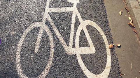 Auf einer Straße ist mit Farbe ein weißes Fahrrad markiert