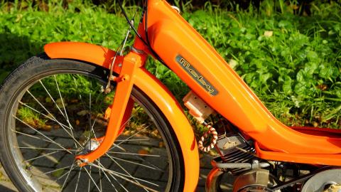 Bild des Vorderrades eines orangfarbenen Mofas