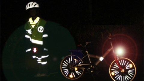 In einer dunklen Szenerie ist links reflektierende Schutzkleidung zu sehen. Rechts Reflektoren am Fahrrad