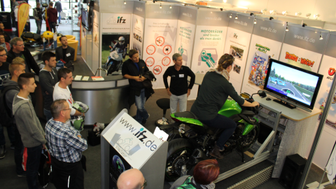 Ein Fahrsimulator für Motorräder. Publikum beobachtet die Fahrt