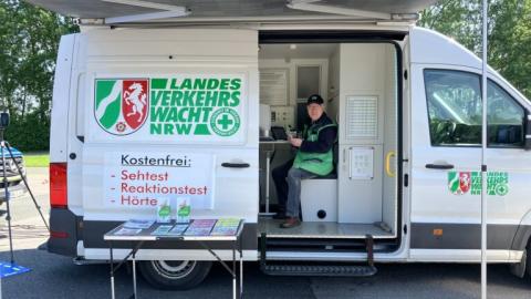 Das Infomobil der Landesverkehrswacht mit geöffneter Seitentür. Darin sitzt ein Mitarbeiter