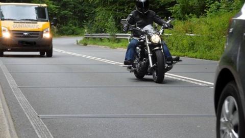 Ein Motorrad auf einer Straße mit baulichen Mängeln