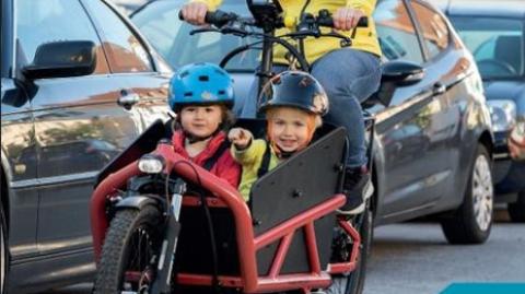 Eine Frau auf dem Lastenrad