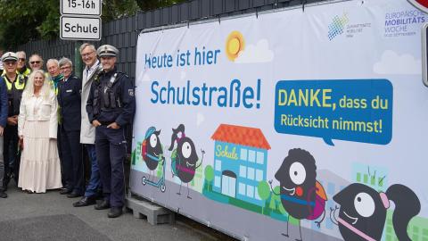Eine Menschengruppe vor dem Plakat zur Fahrradstraße