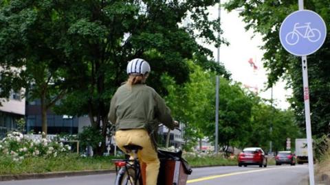 Eine Radfahrerin auf einem Fahrradweg