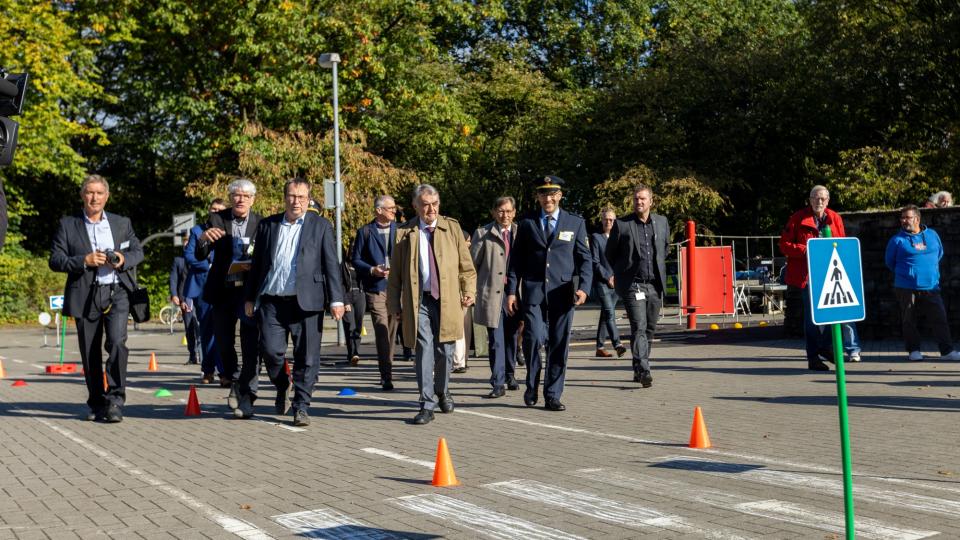 Die Minister Krischer und Reul unterwegs auf dem Veranstaltungsgelände in Herne. Dahinter eine Menschengruppe.