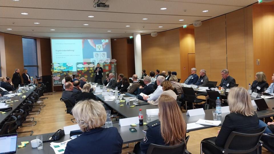 Die Mitglieder der NRW-Initiative sitzen bei der Versammlung in einem Konferenzraum