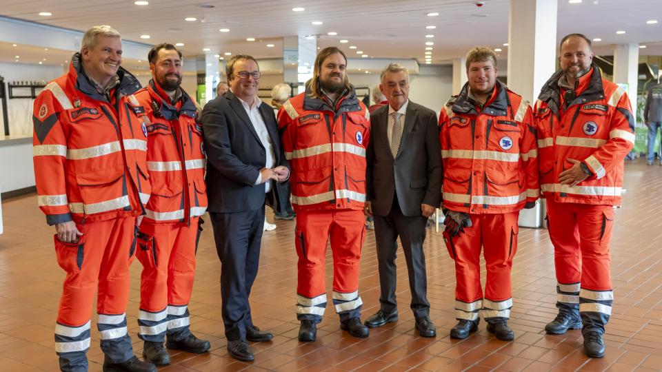 Mitarbeitende des Sanitätsdienstes - dazwischen die Minister Krischer und Reul