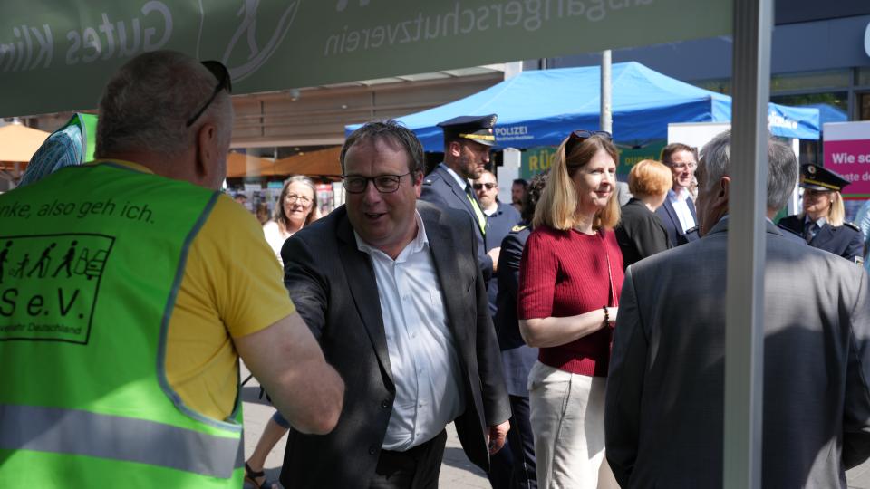 Verkehrsminister Krischer begrüßt einen Aussteller