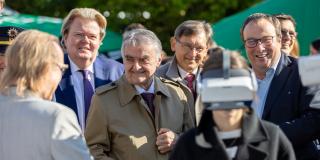 Die Minister Reul und Krischer beim Rundgang über das Veranstaltungsgelände in Herne. Im Vordergrund ein Mädchen mit einer Rauschbrille