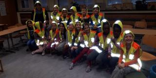 Schulkinder sitzen im dunklen mit reflektierender Kleidung